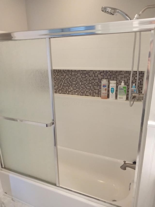 bathroom with shower / bath combination with glass door