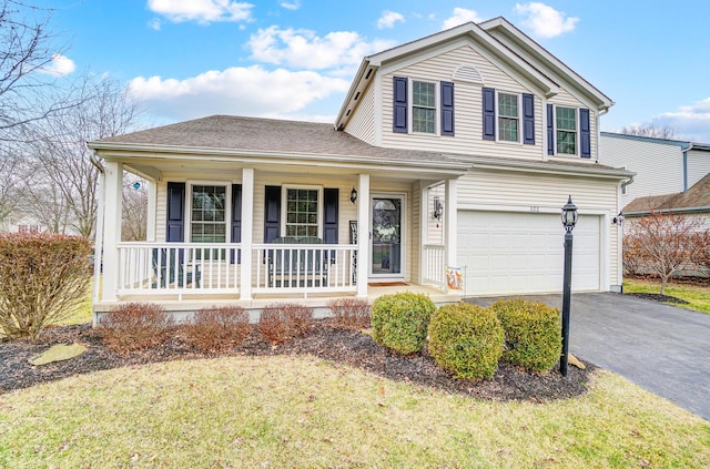 view of front of house with a garage, a front lawn, and covered porch