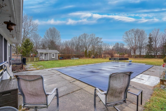 view of pool featuring a patio, a shed, and a lawn