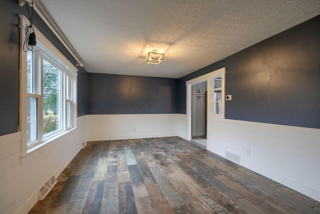 spare room with dark hardwood / wood-style flooring and a textured ceiling