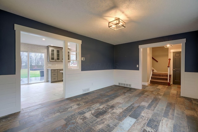 spare room with dark hardwood / wood-style floors and a textured ceiling