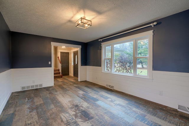 unfurnished room with dark hardwood / wood-style floors and a textured ceiling