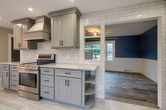 kitchen with premium range hood, stainless steel electric range oven, and gray cabinets