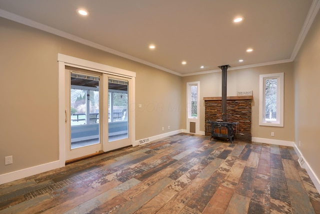 unfurnished living room featuring crown molding, dark hardwood / wood-style floors, and a wood stove