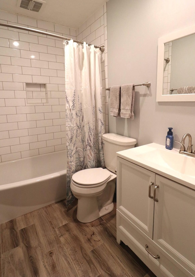 full bathroom featuring wood-type flooring, shower / tub combo, vanity, and toilet