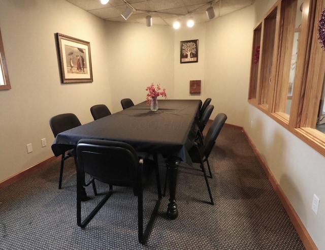 dining space featuring track lighting, a paneled ceiling, and carpet flooring