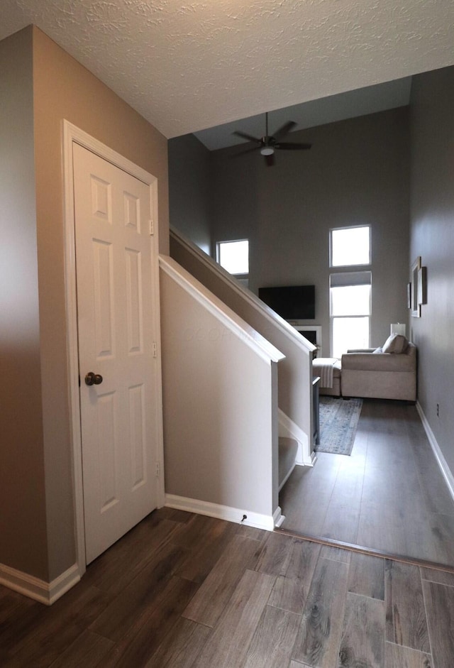 stairway featuring hardwood / wood-style flooring, a textured ceiling, and ceiling fan