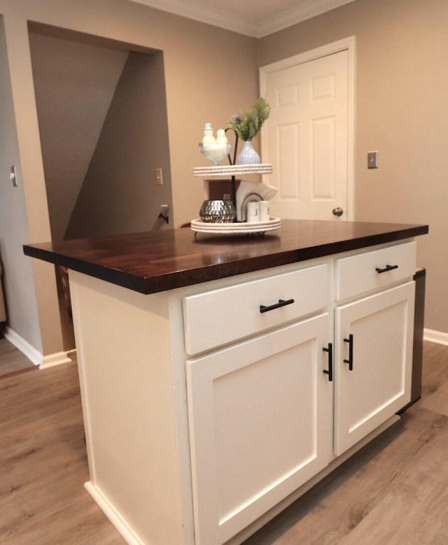 bar featuring white cabinetry, crown molding, and light hardwood / wood-style floors