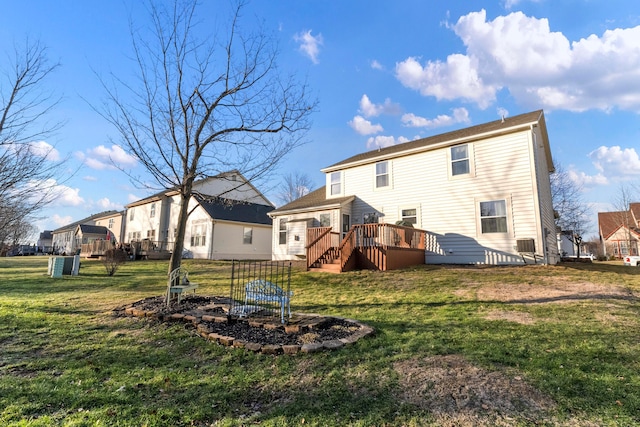 rear view of house with a yard and a deck