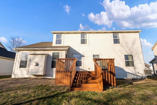 rear view of property with a lawn, central air condition unit, and a deck