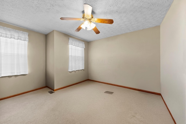 unfurnished room featuring ceiling fan, carpet flooring, and a textured ceiling