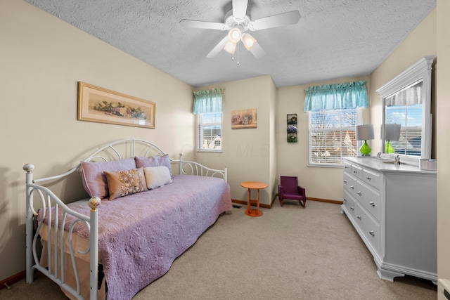 carpeted bedroom featuring ceiling fan and a textured ceiling