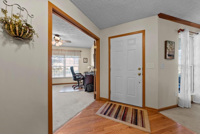 entrance foyer featuring hardwood / wood-style flooring, ceiling fan, and a textured ceiling