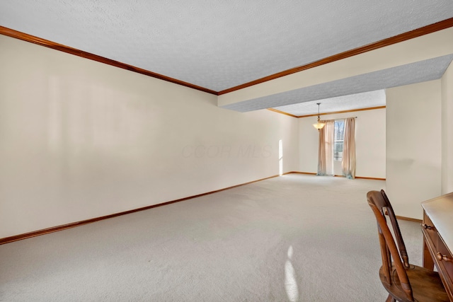 carpeted empty room with crown molding and a textured ceiling