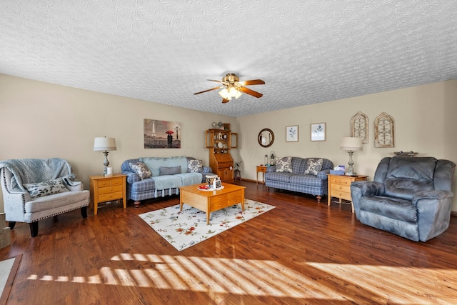 living room featuring ceiling fan, a textured ceiling, and dark hardwood / wood-style flooring