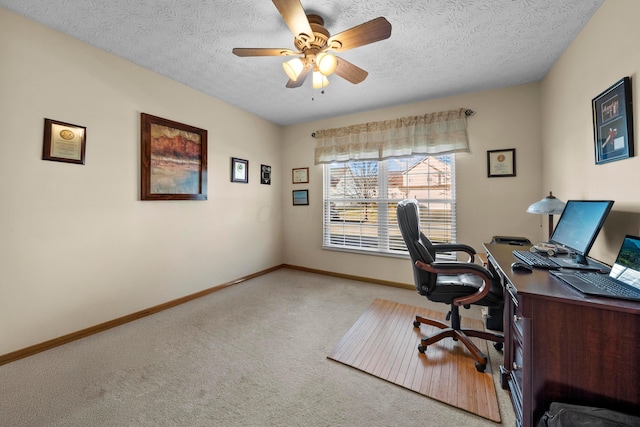 office space featuring light carpet, ceiling fan, and a textured ceiling