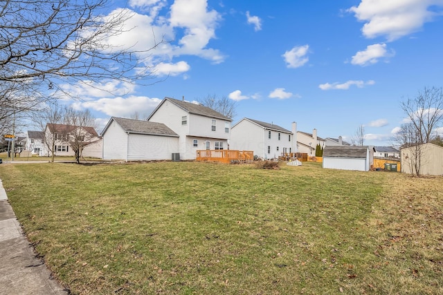 view of side of property with a storage shed, a yard, and a deck