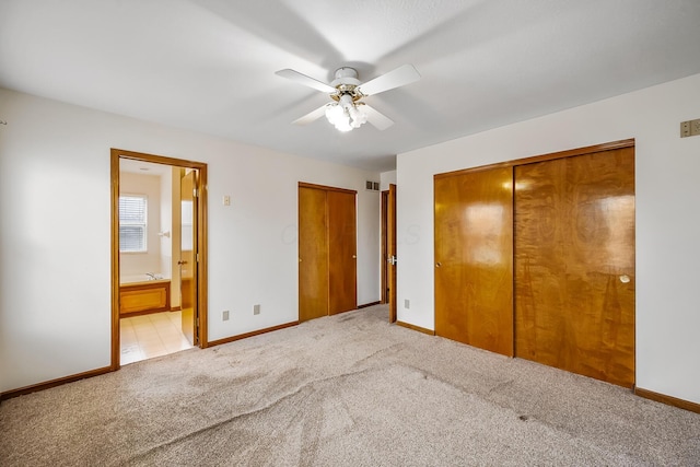 unfurnished bedroom with ensuite bathroom, light colored carpet, and ceiling fan