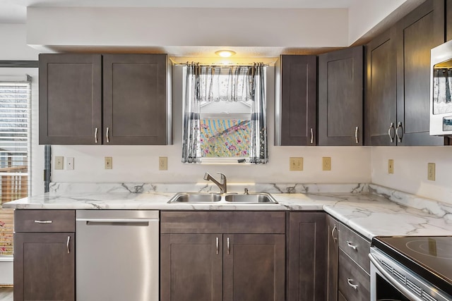 kitchen featuring light stone counters, stainless steel appliances, sink, and dark brown cabinets