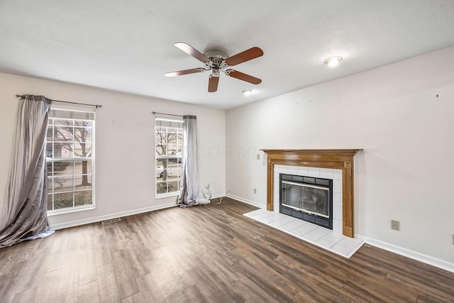 unfurnished living room with hardwood / wood-style flooring, a fireplace, a textured ceiling, and ceiling fan