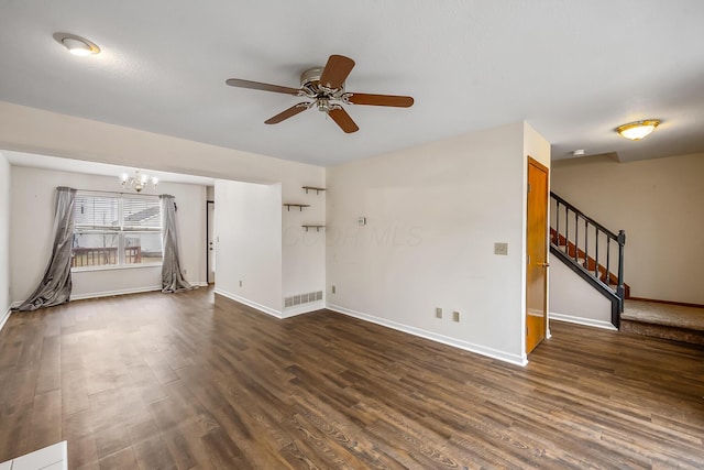 unfurnished living room with dark wood-type flooring and ceiling fan with notable chandelier