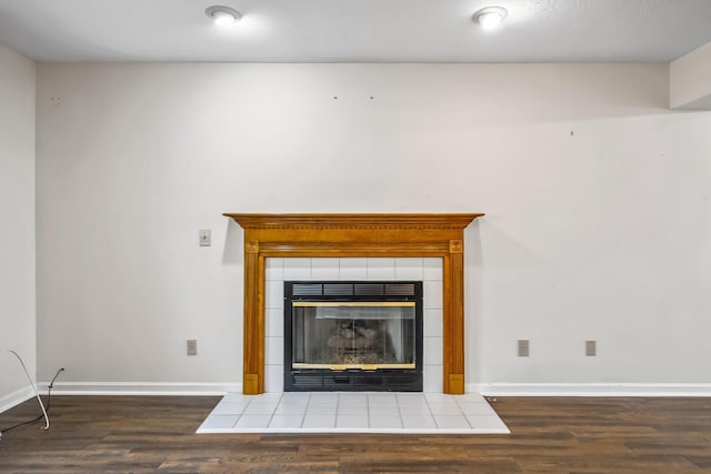 interior details featuring hardwood / wood-style floors and a tile fireplace