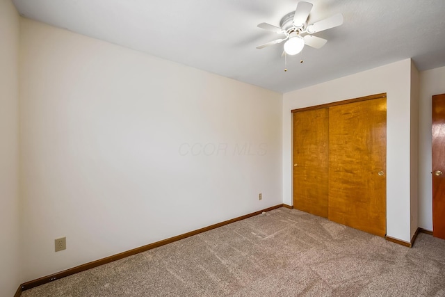 unfurnished bedroom with a closet, ceiling fan, and carpet