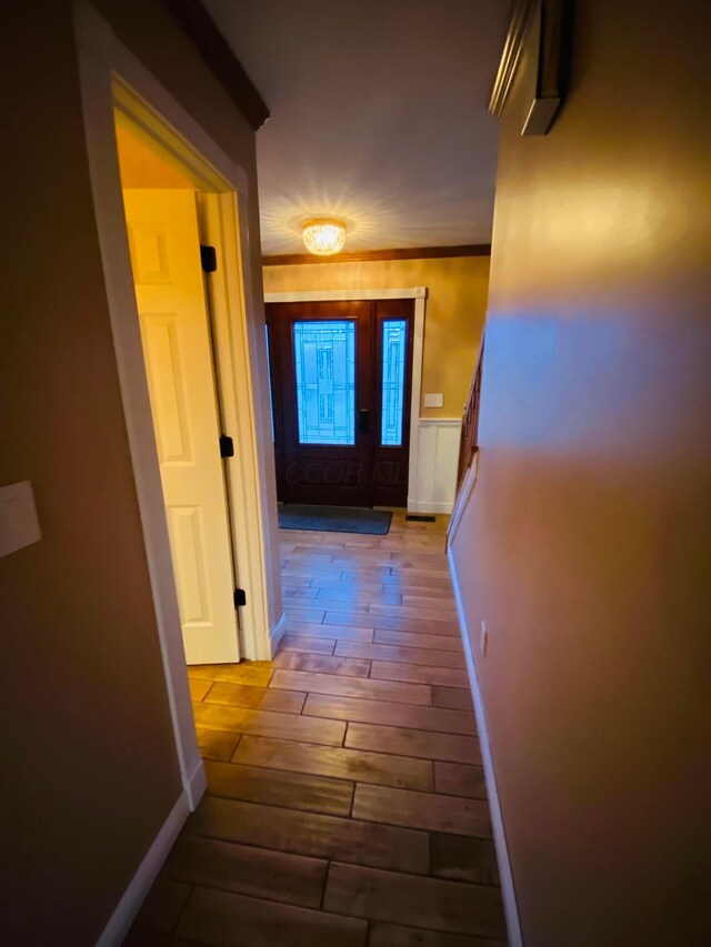 hall featuring crown molding and light hardwood / wood-style floors