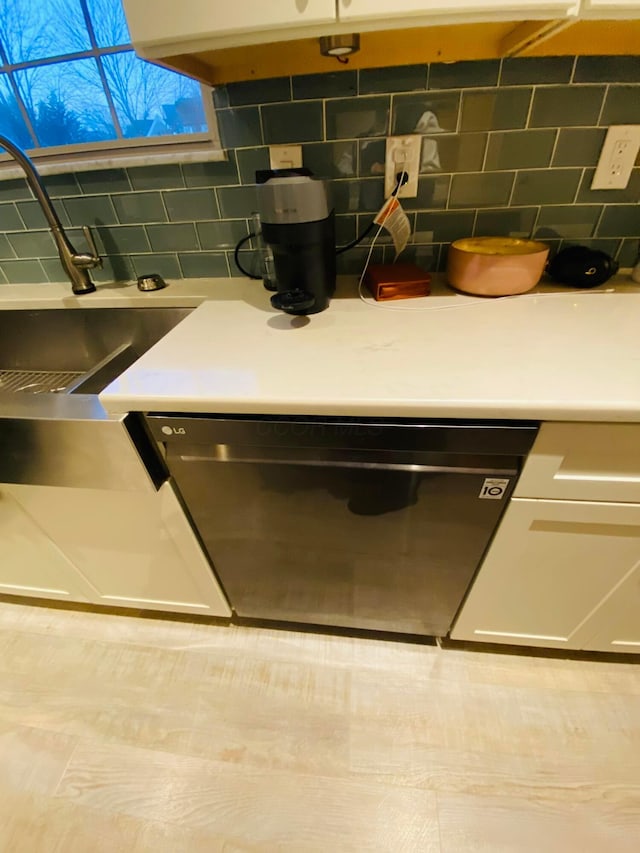 details with white cabinets, decorative backsplash, and black dishwasher