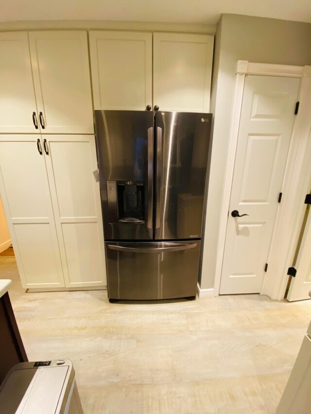 kitchen featuring stainless steel fridge and light hardwood / wood-style flooring