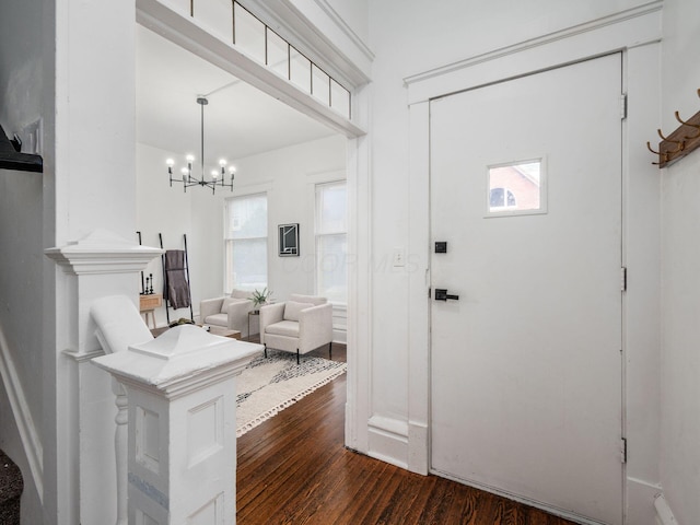 entryway with an inviting chandelier and dark hardwood / wood-style flooring