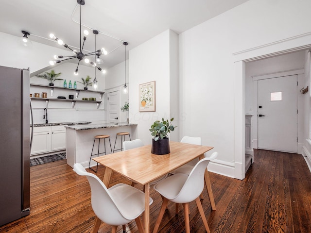 dining area featuring sink, a chandelier, and dark hardwood / wood-style flooring