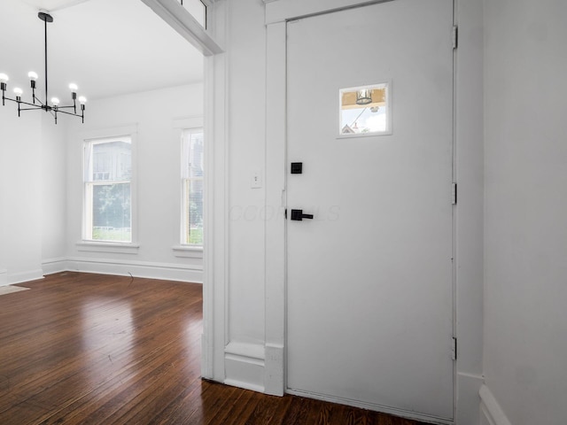 entrance foyer with dark wood-type flooring and an inviting chandelier