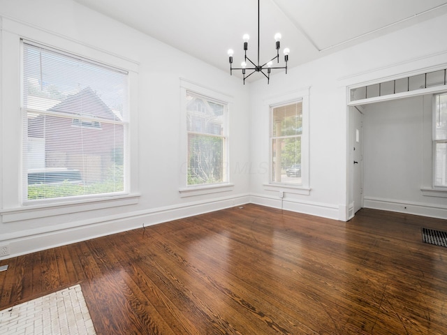 unfurnished dining area featuring a chandelier and hardwood / wood-style floors