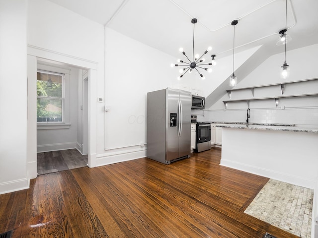 kitchen featuring appliances with stainless steel finishes, white cabinetry, a notable chandelier, light stone countertops, and decorative light fixtures