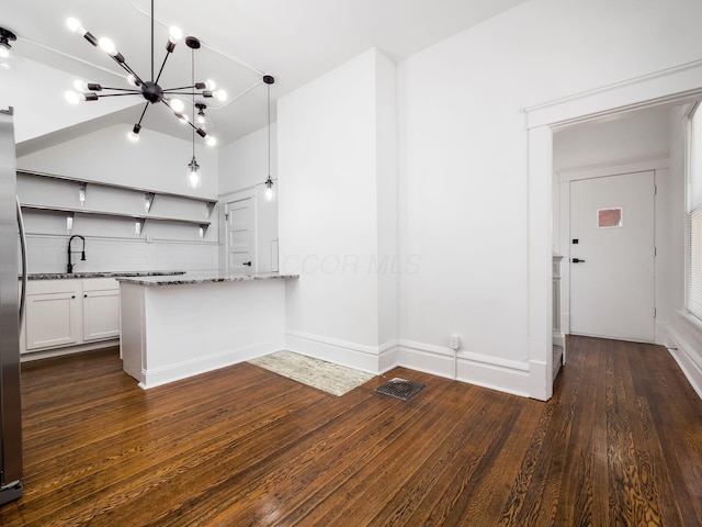 kitchen featuring hanging light fixtures, white cabinets, stone countertops, dark hardwood / wood-style flooring, and kitchen peninsula