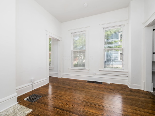 unfurnished room with dark hardwood / wood-style flooring