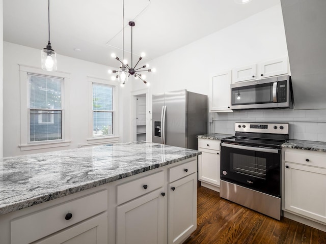 kitchen featuring stainless steel appliances, white cabinetry, hanging light fixtures, and light stone countertops