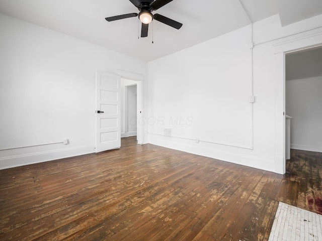 spare room featuring dark wood-type flooring and ceiling fan