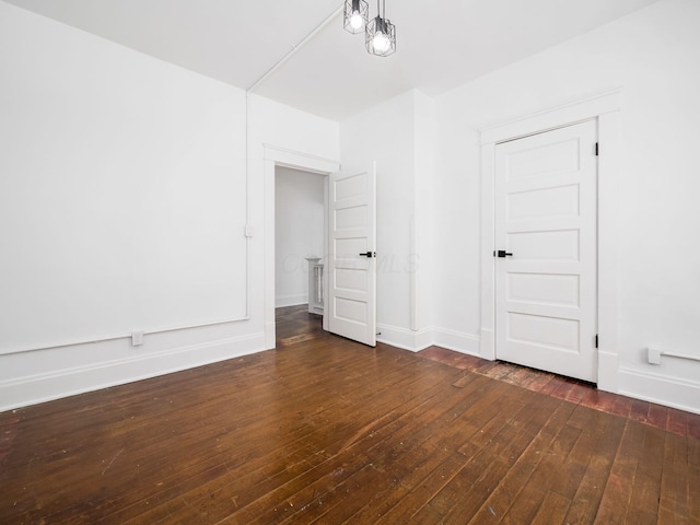 unfurnished room with dark wood-type flooring