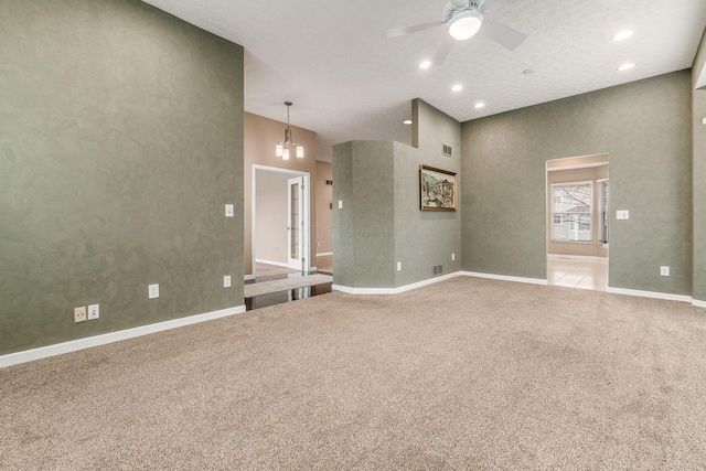 unfurnished living room with light colored carpet, ceiling fan, and a high ceiling