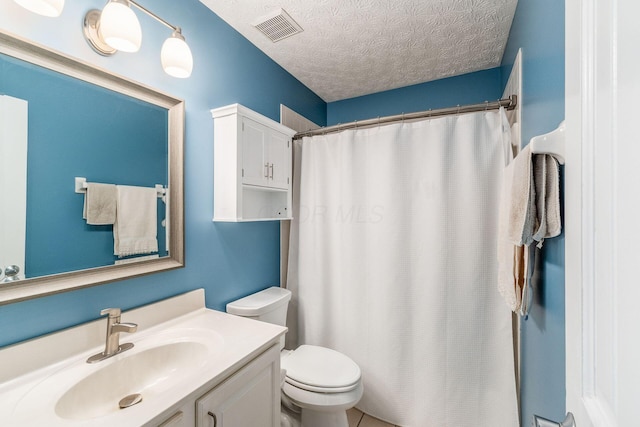 bathroom featuring vanity, toilet, and a textured ceiling