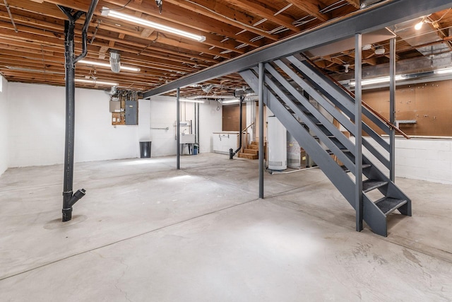 basement featuring electric panel and water heater