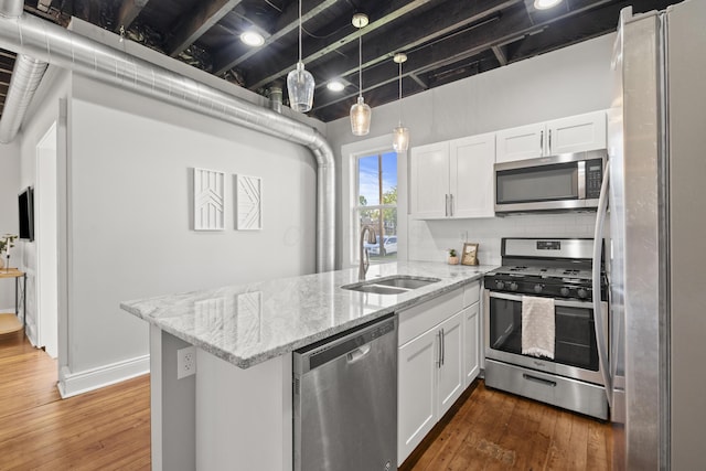 kitchen featuring stainless steel appliances, kitchen peninsula, sink, and white cabinets