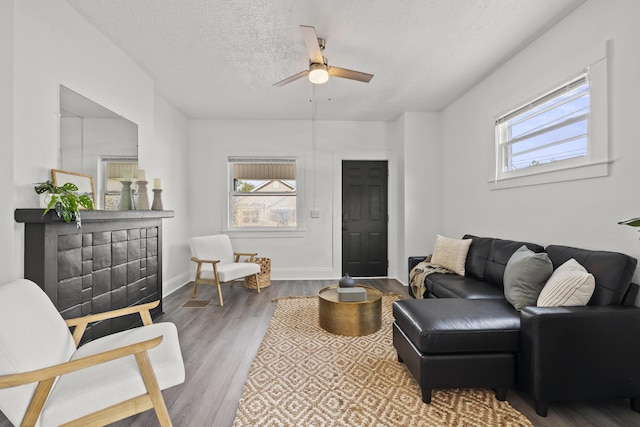 living room featuring ceiling fan, hardwood / wood-style floors, and a textured ceiling