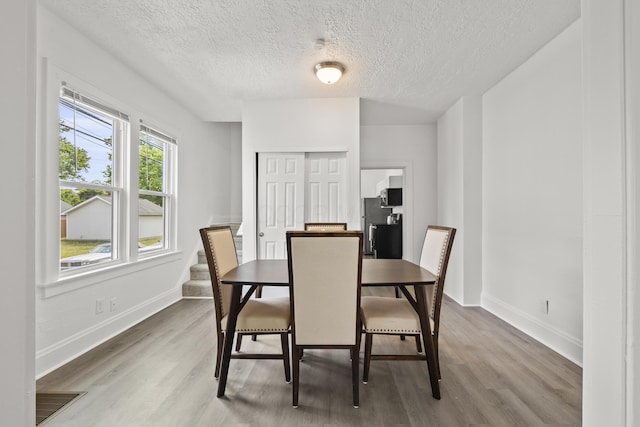 dining area featuring hardwood / wood-style floors and a textured ceiling