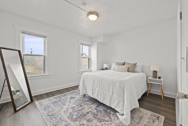 bedroom featuring dark hardwood / wood-style flooring and a textured ceiling