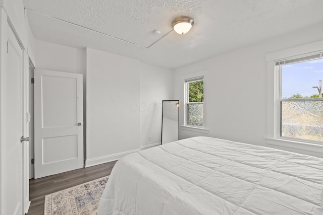 bedroom with wood-type flooring and a textured ceiling