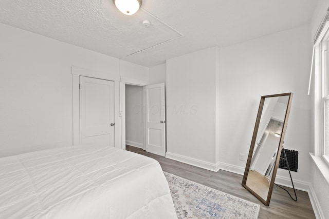 bedroom with hardwood / wood-style flooring and a textured ceiling