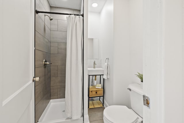 bathroom featuring toilet, sink, and walk in shower